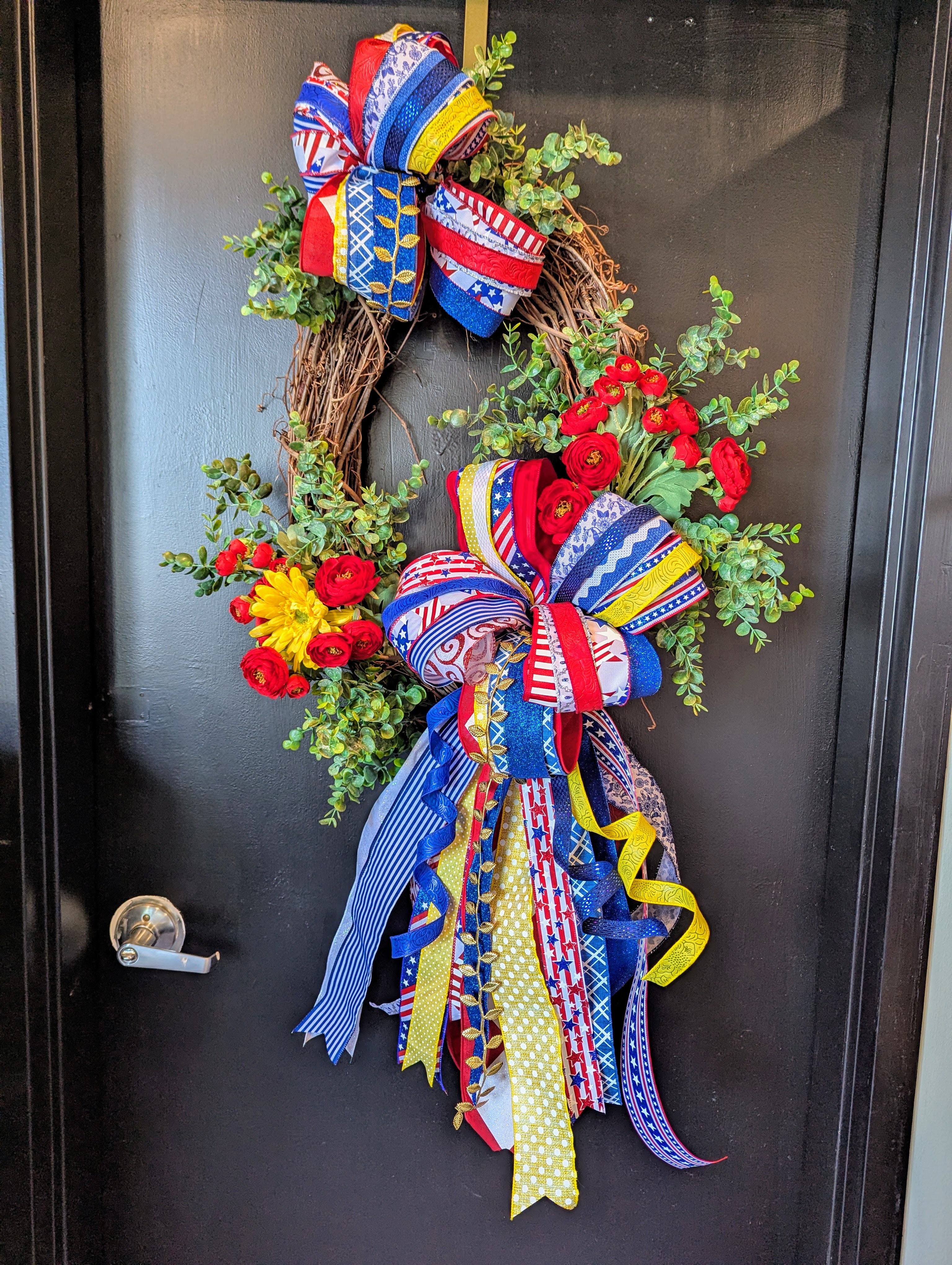Memorial Day wreath with red, white, and blue ribbon by Place Makers